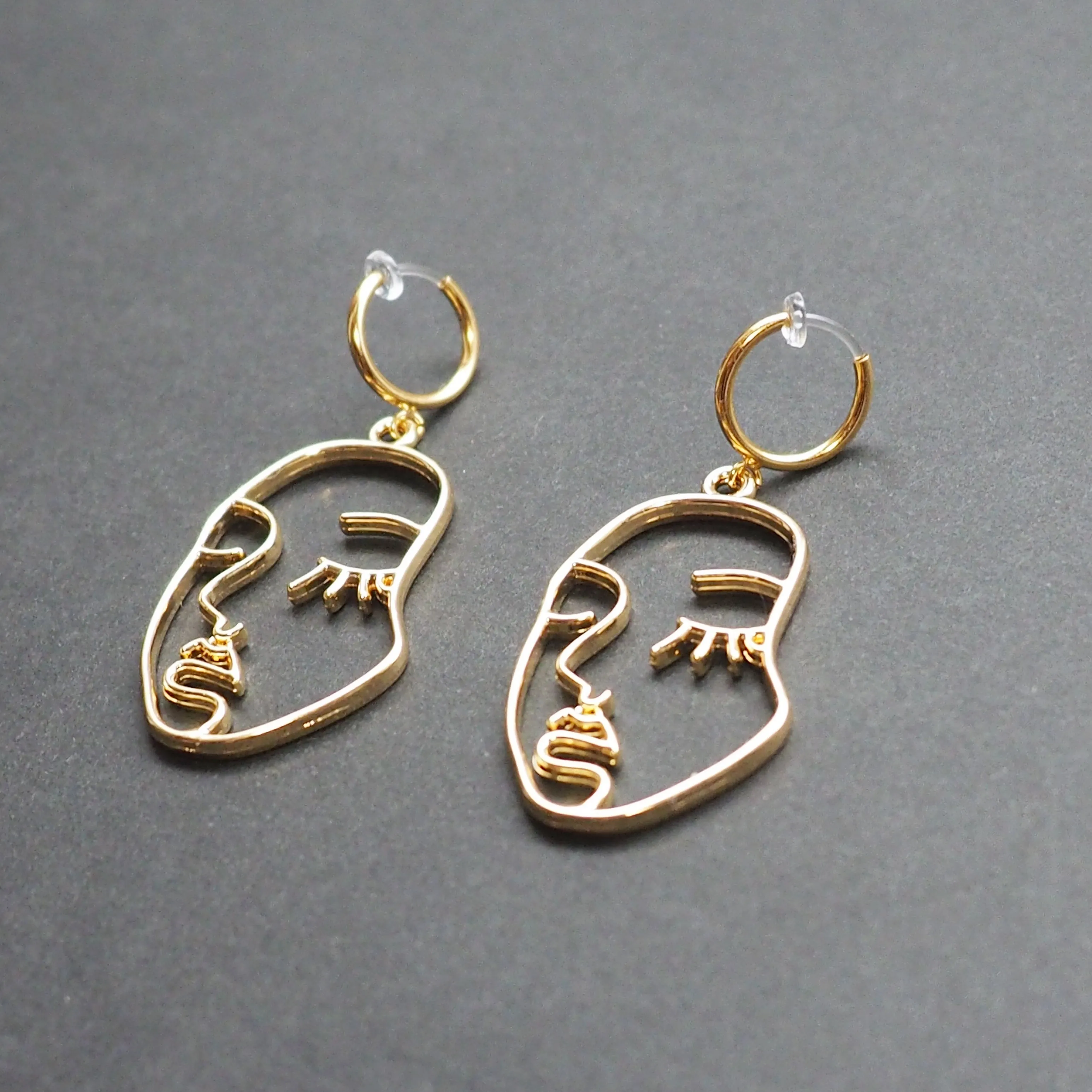 Gold human face clip on hoop earrings