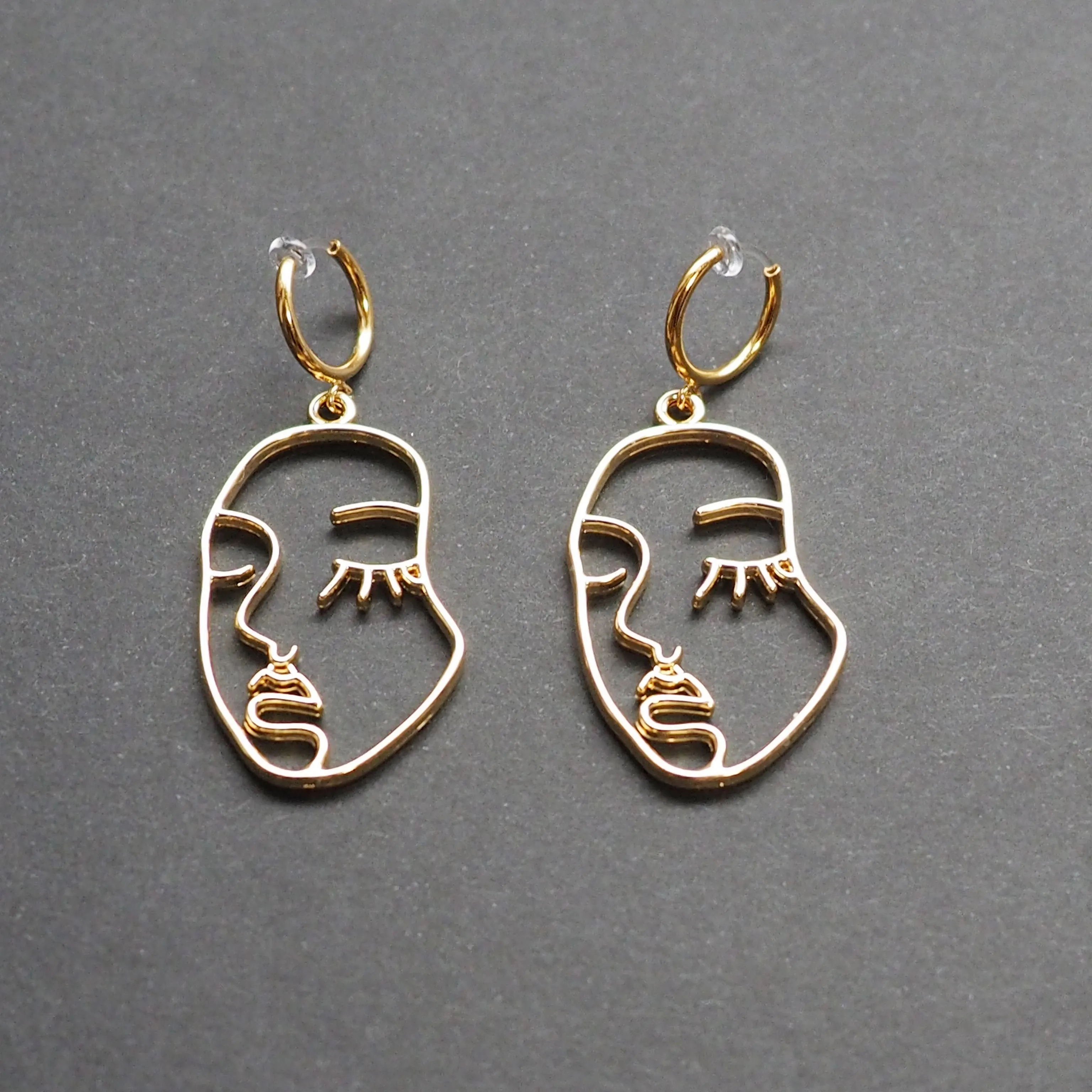 Gold human face clip on hoop earrings